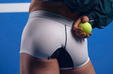Close-up of the white PUMP! Deuce Boxer with the model holding a tennis ball