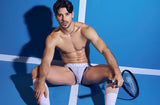 Model seated on a blue tennis court wearing the PUMP! Net Sidecut Brief