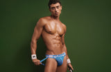 Model in the blue PUMP! Smash Jockstrap holding a tennis racket